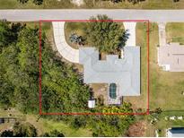 Beautiful aerial view of home with landscaped yard, circular driveway, and private screened-in pool at 7328 Yardley St, Englewood, FL 34224