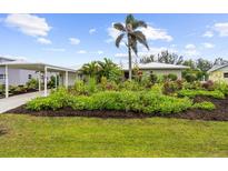 Charming home featuring lush landscaping and a beautiful palm tree at 7339 Thomas St, Englewood, FL 34224