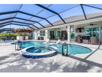 Enjoy the Florida sunshine in this enclosed pool area featuring a spa and comfortable seating at 14564 Gaspar Loop, Port Charlotte, FL 33981