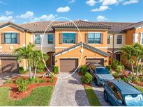 Charming two-story townhome with a tile roof, attached garage, and lush landscaping at 20279 Lagente Cir, Venice, FL 34293