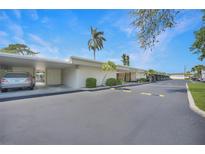 Well maintained condo building exterior with palm trees and covered parking on a sunny day at 2437 Harbor Blvd # 204, Port Charlotte, FL 33952