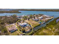 Beautiful waterfront property with a pool and private dock on a sunny day at 50 Spyglass Aly, Placida, FL 33946