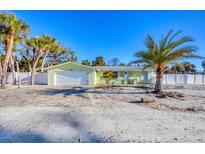 Charming coastal home featuring a paved driveway and lush tropical landscaping at 6035 Manasota Key Rd, Englewood, FL 34223