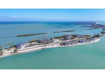 Stunning aerial view of a coastal property featuring multiple residences, boat docks, and beautiful turquoise water at 6040 Boca Grande Cswy # A2, Boca Grande, FL 33921