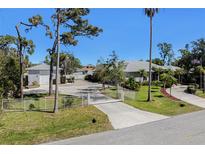 Beautiful property with manicured lawn, gated entrance, mature trees, and a detached garage at 820 Bayshore Dr, Englewood, FL 34223