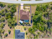 Beautiful aerial view of the home showing the private pool, large yard, and desirable landscaping at 8251 Arlewood Cir, Port Charlotte, FL 33981