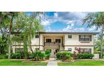 Inviting two-story condo with charming exterior, lush landscaping, and convenient stair access to the upper units at 19505 Quesada Ave # B202, Port Charlotte, FL 33948