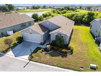Charming home features a well-manicured lawn, an attached garage, and proximity to a scenic pond and golf course at 24135 Buckingham Way, Punta Gorda, FL 33980
