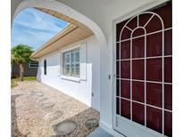 Inviting front entrance with decorative screen door, stone pathway, and bright natural light at 7215 Brookhaven Ter, Englewood, FL 34224