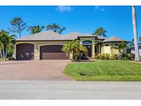 Beautiful single-story home featuring a three-car garage, manicured lawn, and elegant landscaping at 758 Rotonda Cir, Rotonda West, FL 33947