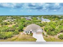 Well maintained single Gathering home with landscaped front yard, long driveway, and attached two car garage at 9283 Impala Cir, Port Charlotte, FL 33981