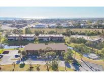 Aerial view of property surrounded by lush landscaping and water features, offering a serene setting at 11 Quails Run Blvd # 9, Englewood, FL 34223