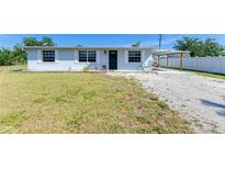Charming single-story home with light blue exterior, well-maintained lawn, and convenient carport at 1160 Sharlo Cir, Englewood, FL 34224
