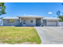 Charming single story home featuring a large front yard, stone accents, and a two car garage at 150 Crestview Dr, Englewood, FL 34223
