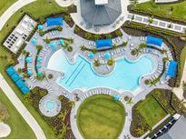 Aerial view of a resort-style pool with lounge chairs, umbrellas, and well-manicured landscaping, ideal for relaxation and recreation at 17685 Boracay Ct # 202, Venice, FL 34293