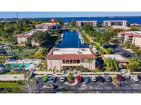 Scenic aerial view of community with a pool, tennis court, canal access, and ample parking at 25188 Marion Ave # D308, Punta Gorda, FL 33950