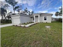 A charming single-story home featuring a well-manicured lawn and attached one car garage at 302 Albatross Rd, Rotonda West, FL 33947