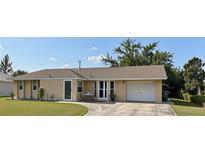 Charming single-story home with a well-manicured lawn and a convenient attached one car garage at 3415 Gulf Ln, Rotonda West, FL 33947