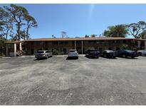 Two story condo with a large parking lot and multiple cars at 5 Quails Run Blvd # 9, Englewood, FL 34223