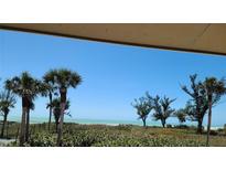 Expansive beach view with palm trees, lush foliage, and clear blue skies from this inviting property at 5800 Gulf Shores Dr # 25, Boca Grande, FL 33921