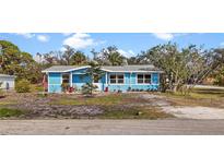 Charming light blue single-story home with a quaint front yard and ample natural light, creating a welcoming curb appeal at 7035 Duke St, Englewood, FL 34224
