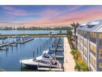 Scenic view of a marina with boat docks, a luxury yacht, and waterfront condos under a colorful sky at sunset at 7070 Placida Rd # 1230, Placida, FL 33946