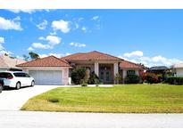 Charming single-story home features a well-maintained lawn, two-car garage, and a beautiful tile roof at 76 Sportsman Rd, Rotonda West, FL 33947