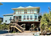 Stunning elevated coastal home featuring a spacious porch and outdoor living space at 8152 Little Gasparilla Is, Placida, FL 33946