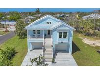 Charming coastal home with a metal roof, double garage, and inviting staircase at 1141 Andrews St, Englewood, FL 34224