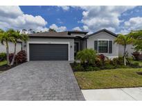 Attractive single-Gathering home with a stone-paved driveway and neatly manicured lawn at 15968 Honeysuckle St, Port Charlotte, FL 33953