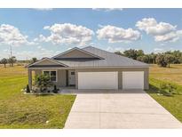 Charming single-story home with a spacious driveway and well-manicured lawn, featuring a three-car garage at 16489 Trading Post Rd, Punta Gorda, FL 33955