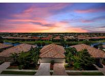 Stunning exterior of home at sunset with meticulously landscaped grounds and tile roof at 20171 Tesoro Dr, Venice, FL 34293