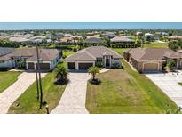Beautiful single-Gathering home features a three-car garage, manicured lawn, and brick paver driveway at 212 Rotonda E Blvd, Rotonda West, FL 33947