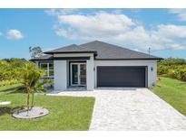 Charming single-story home featuring a gray roof, a gray garage door, and a well-manicured lawn at 234 Cougar Way, Rotonda West, FL 33947