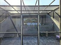 View of the screened lanai with brick pavers and view of the home's entrance at 351 Bobby Jones Rd # 351, Sarasota, FL 34232