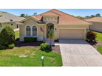 Charming single-story home featuring a red tile roof, manicured lawn, and a two-car garage at 13217 Scrub Jay Ct, Port Charlotte, FL 33953