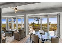 Bright dining area with beach views through large windows and comfortable seating at 17 Seawatch Dr, Boca Grande, FL 33921