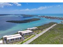 Stunning aerial view of waterfront condos, with lush landscaping and beautiful ocean views at 1701 Beach Rd # 208, Englewood, FL 34223
