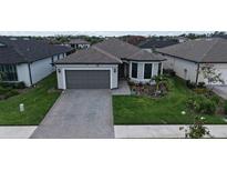 Charming single-story home featuring a manicured lawn and a two-car garage at 2117 Laurifolia Ct, North Port, FL 34289