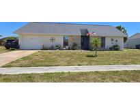Charming single-story home with a well-maintained lawn and an attached two-car garage at 6540 Coliseum Blvd, Port Charlotte, FL 33981