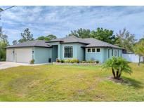 Charming single-story home with a well-manicured lawn and a two-car garage, complemented by lush landscaping at 7108 Harle Ave, North Port, FL 34291