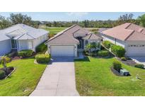 Charming single-story home featuring lush landscaping, tile roof, and a well-manicured lawn at 105 Westwind Dr, Placida, FL 33946