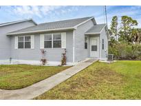 Charming single-story home featuring a well-maintained lawn and inviting walkway at 14454 Worthwhile Rd, Port Charlotte, FL 33953