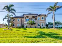 Charming two-story home featuring a lovely front yard, second story balcony, and beautiful landscaping at 1953 Georgia Ave, Englewood, FL 34224