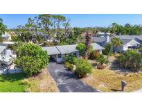 Aerial view of a single-story home with a carport, mature trees, and a well-manicured lawn in a quiet neighborhood at 2128 Pennsylvania Ave, Englewood, FL 34224
