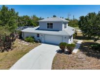 Two-story home featuring an attached garage and a long driveway leading up to the house at 270 E Wentworth St, Englewood, FL 34223