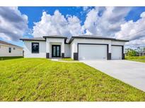 Beautiful new construction home with a three car garage and a well manicured lawn at 40 Golfview Ct, Rotonda West, FL 33947