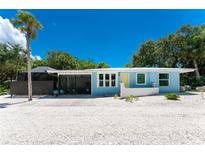 Charming blue single-story home with a screened-in porch and well-kept landscaping at 4065 N Beach Rd # A, Englewood, FL 34223