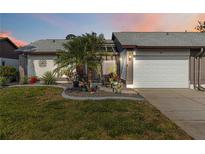 Charming single-story home features a well-manicured lawn, lovely landscaping, and an attached two-car garage at 667 Foxwood Blvd, Englewood, FL 34223