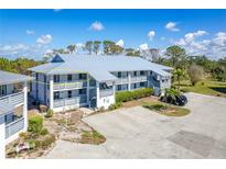 Condominium exterior featuring a gray metal roof and a private balcony with seating and manicured landscaping at 6800 Placida Rd # 262, Englewood, FL 34224